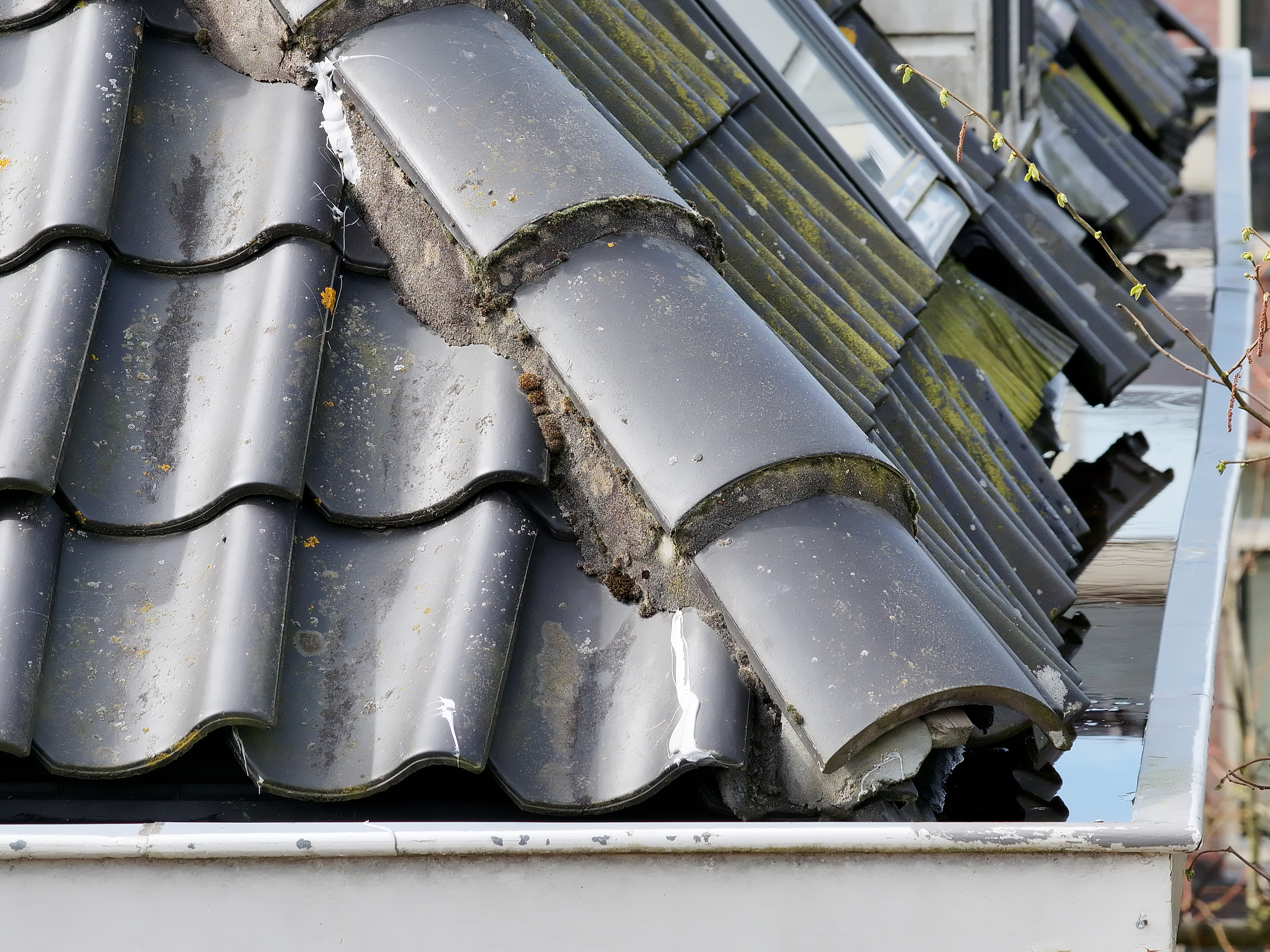 Detailopname van beschadigde dakranden en nokvorsten