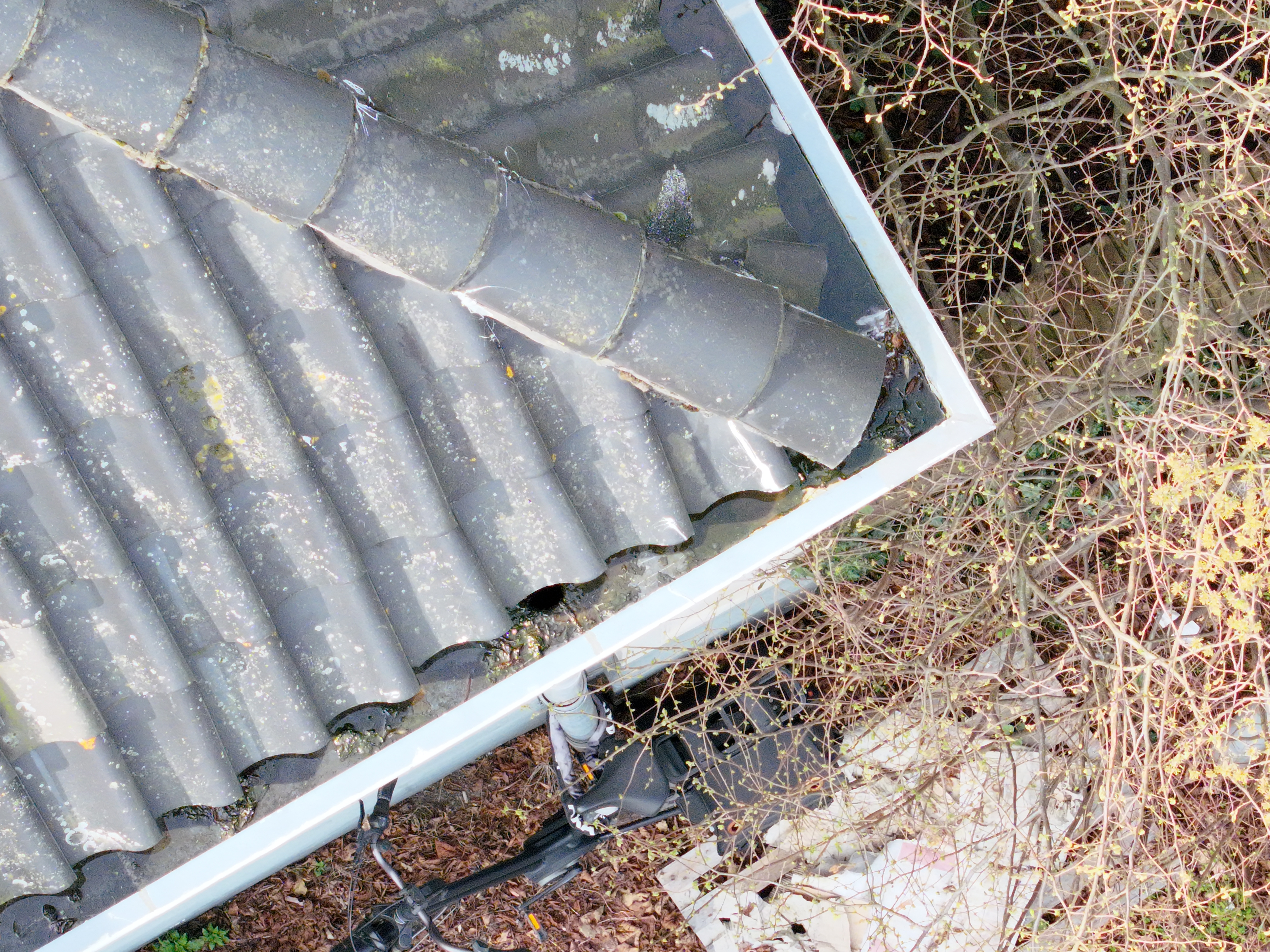 Luchtfoto van een dakhoek met zicht op goten en dakpannen